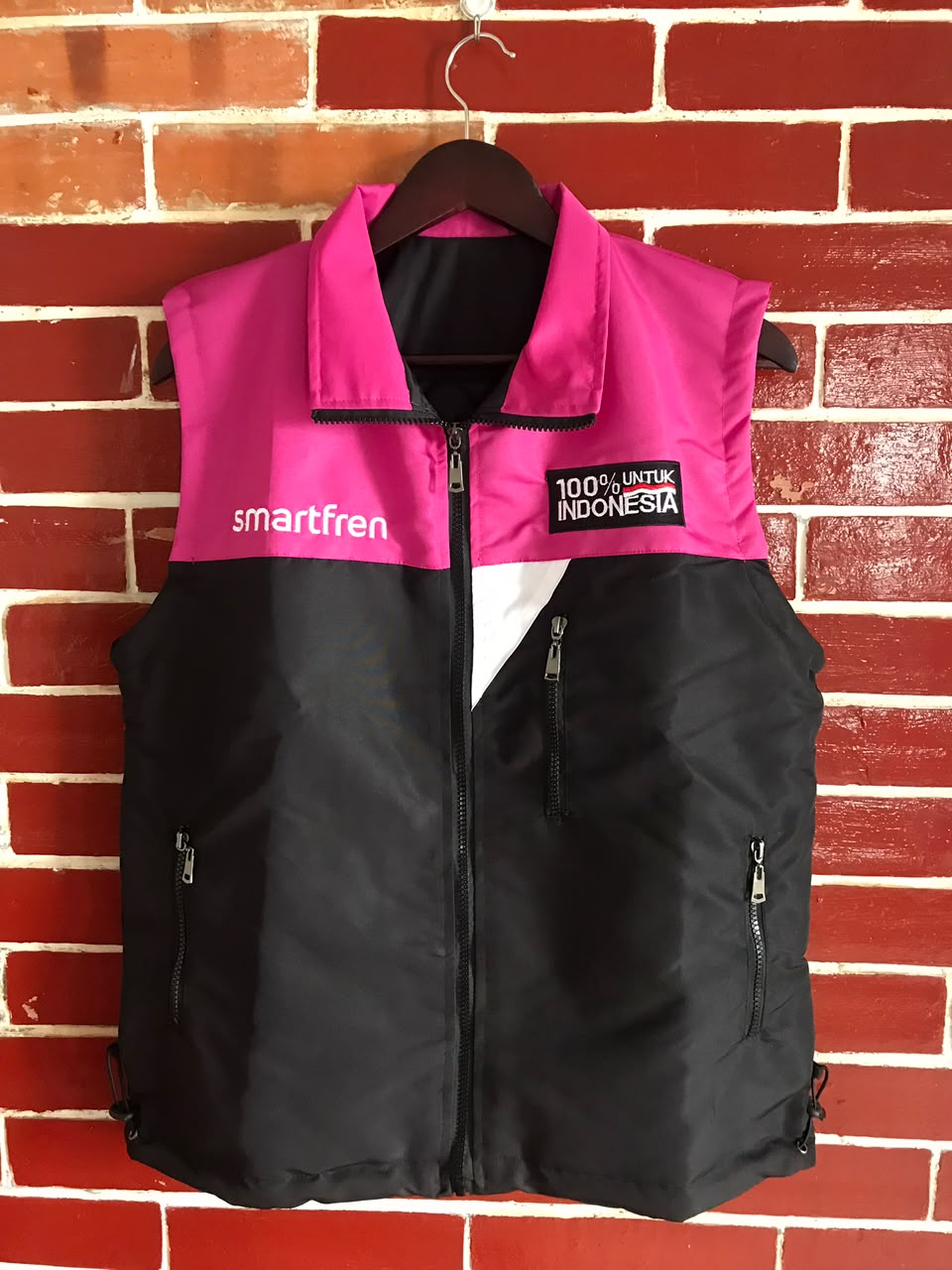Smartfren vest displayed against a brick wall